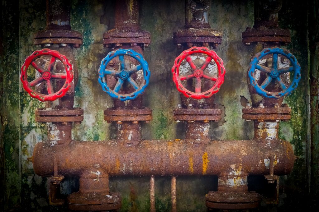 4 round wheel handles on a rusty pipe